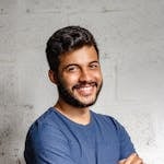 Portrait of a happy man with arms crossed, exuding confidence and friendliness.